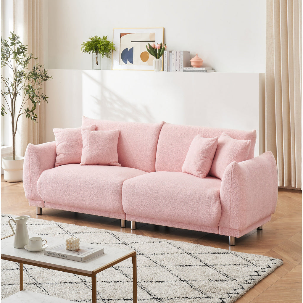 Un canapé rose en polaire de 86,6 pouces avec quatre coussins et des pieds en quincaillerie peut s'asseoir confortablement dans une chambre d'appartement