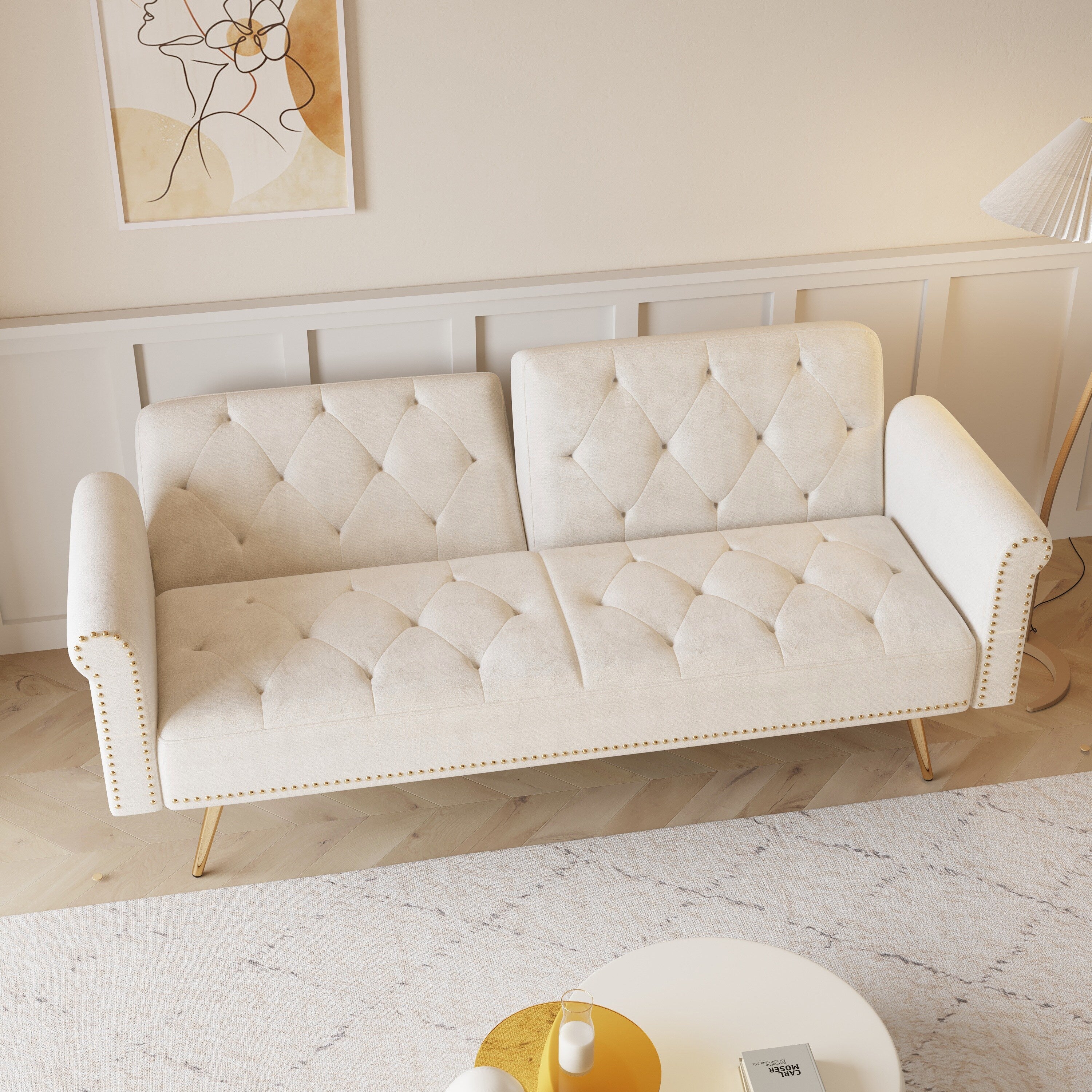 Un canapé-lit de 176 cm de long recouvert de velours, orné d'une bordure cloutée et accompagné d'un coussin assorti.