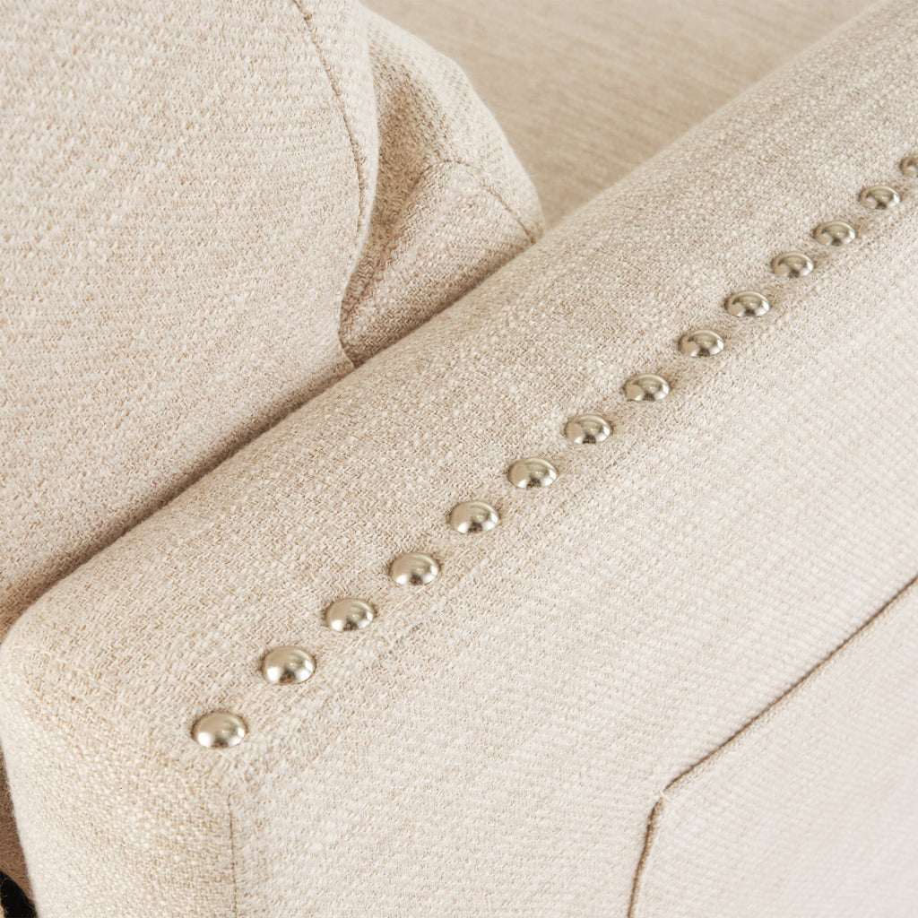 Fauteuil inclinable moderne en tissu beige avec repose-pieds, clous décoratifs et pieds en bouleau