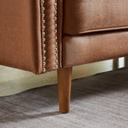 Canapé 3 places en cuir synthétique marron de 208 cm, forme L, avec méridienne gauche et clous décoratifs, finitions en cuivre et pieds en bois massif.