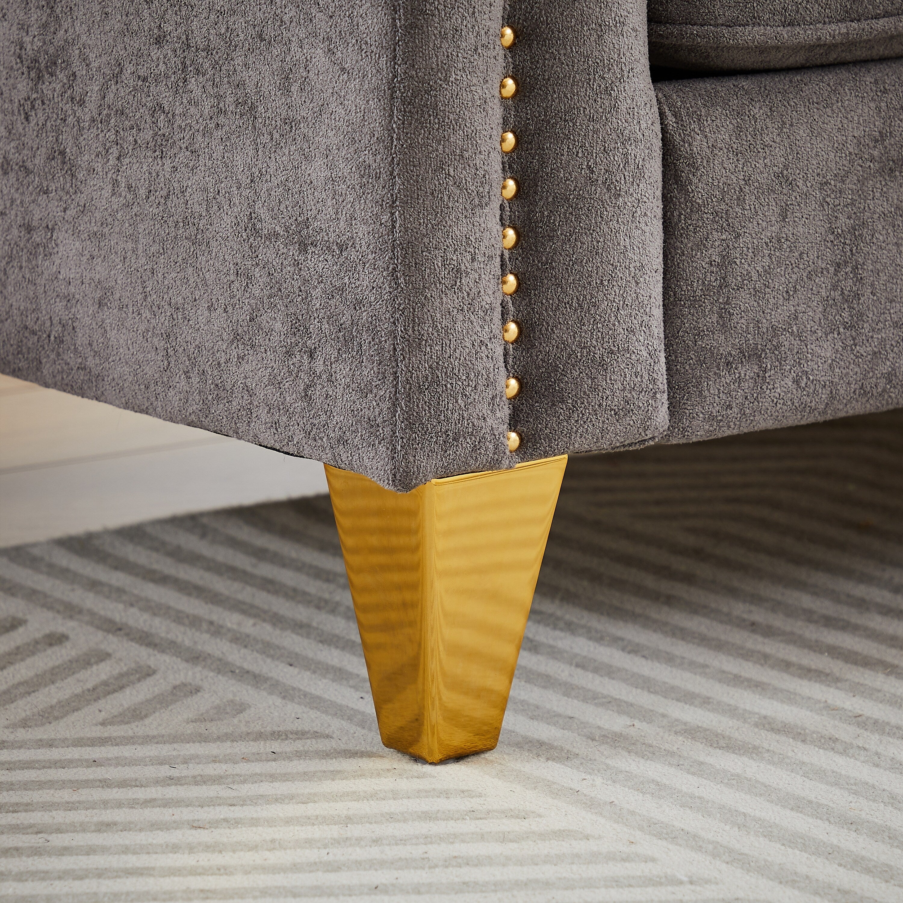 Canapé capitonné 3 places en chenille avec décoration cloutée en cuivre